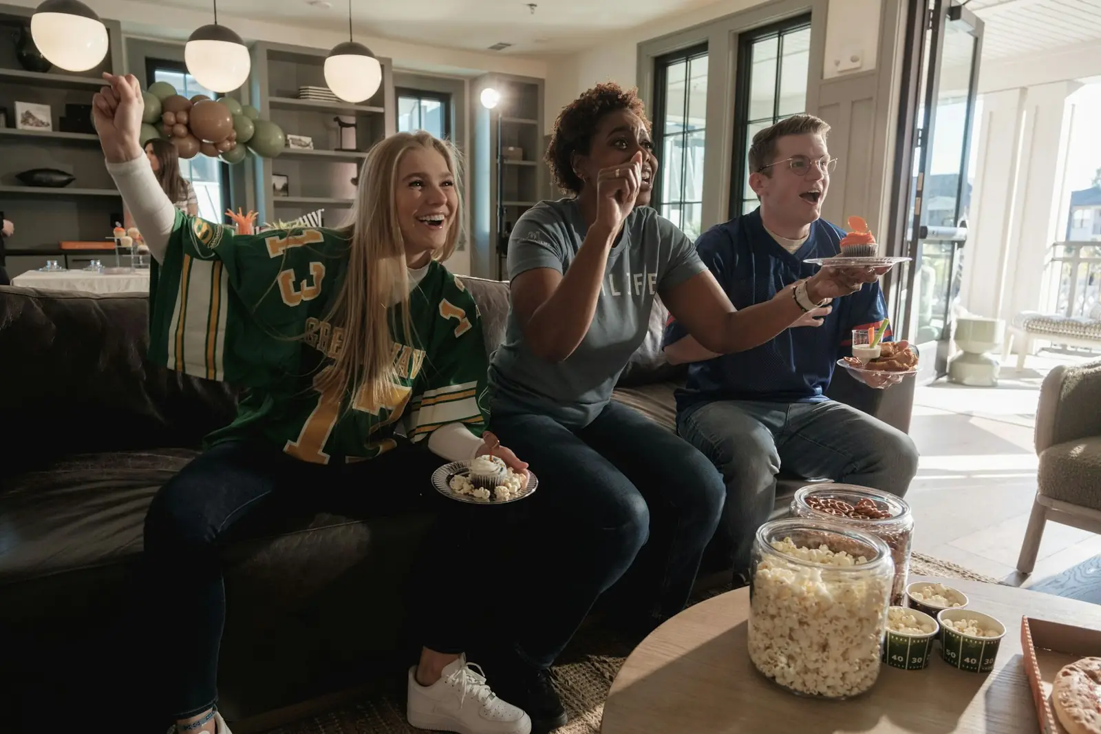 Friends cheering while watching a live match on TV at home